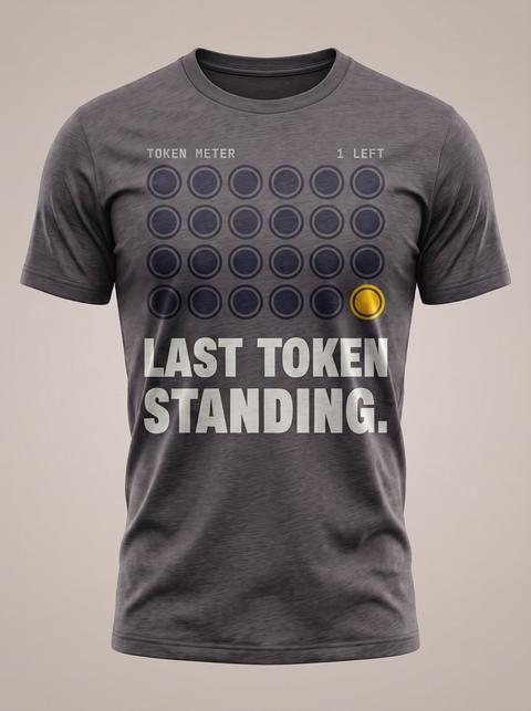 The Last Token tee in Charcoal. Fitted mockup. Printed: TOKEN METER / 1 LEFT / LAST TOKEN / STANDING.